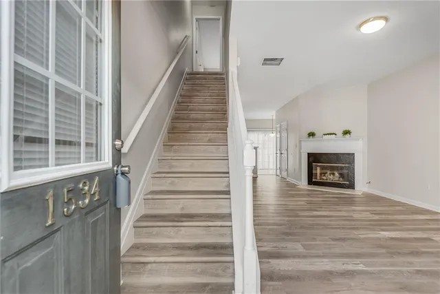 a view of an entryway with wooden floor and a fireplace