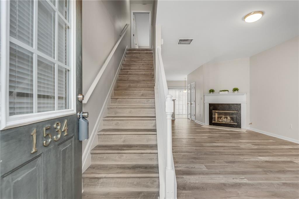 1534 Cove Creek Circle Norcross, GA 30093 - Photo 7 of 33 a view of an entryway with wooden floor and a fireplace