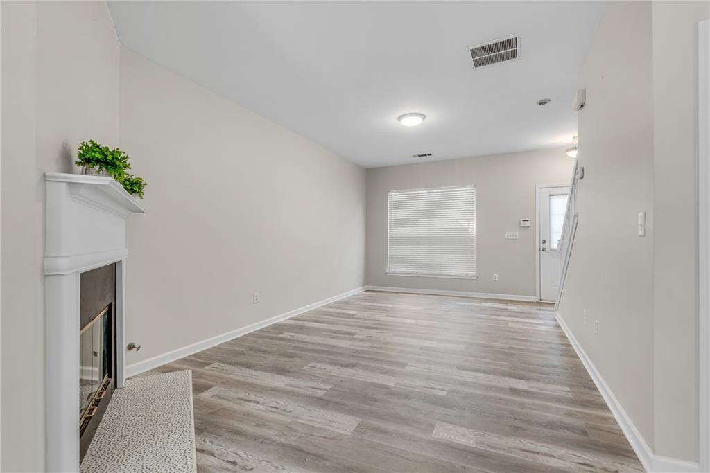 1534 Cove Creek Circle Norcross, GA 30093 - Photo 9 of 33 a view of an empty room with wooden floor and a window