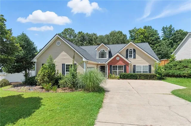 a view of house with garden and tall trees