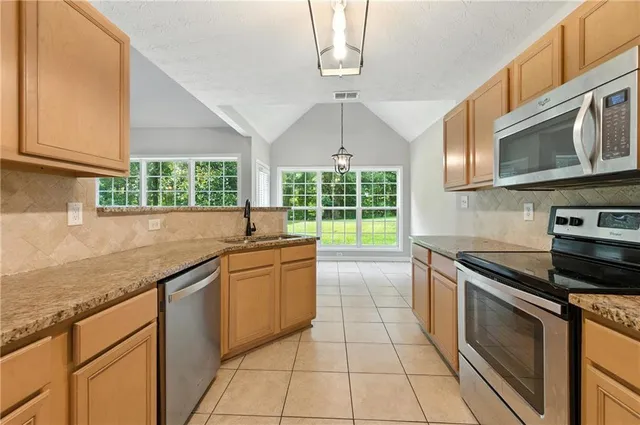 a view of a kitchen with a sink refrigerator and wooden floor