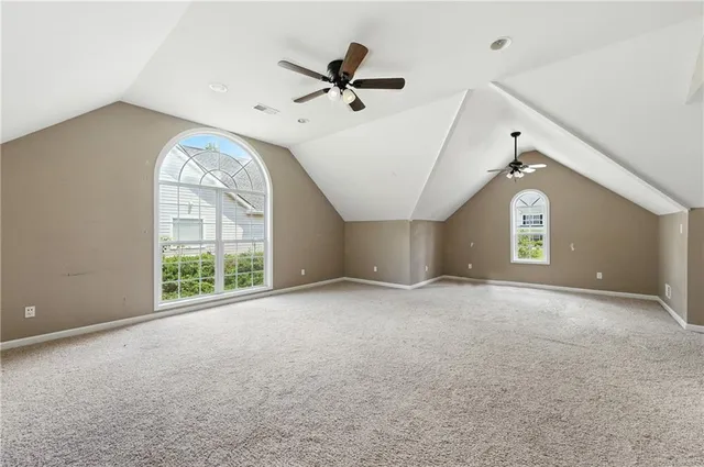 an empty room with a window and a ceiling fan