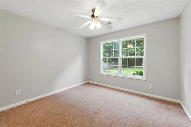an empty room with a fan and a ceiling fan