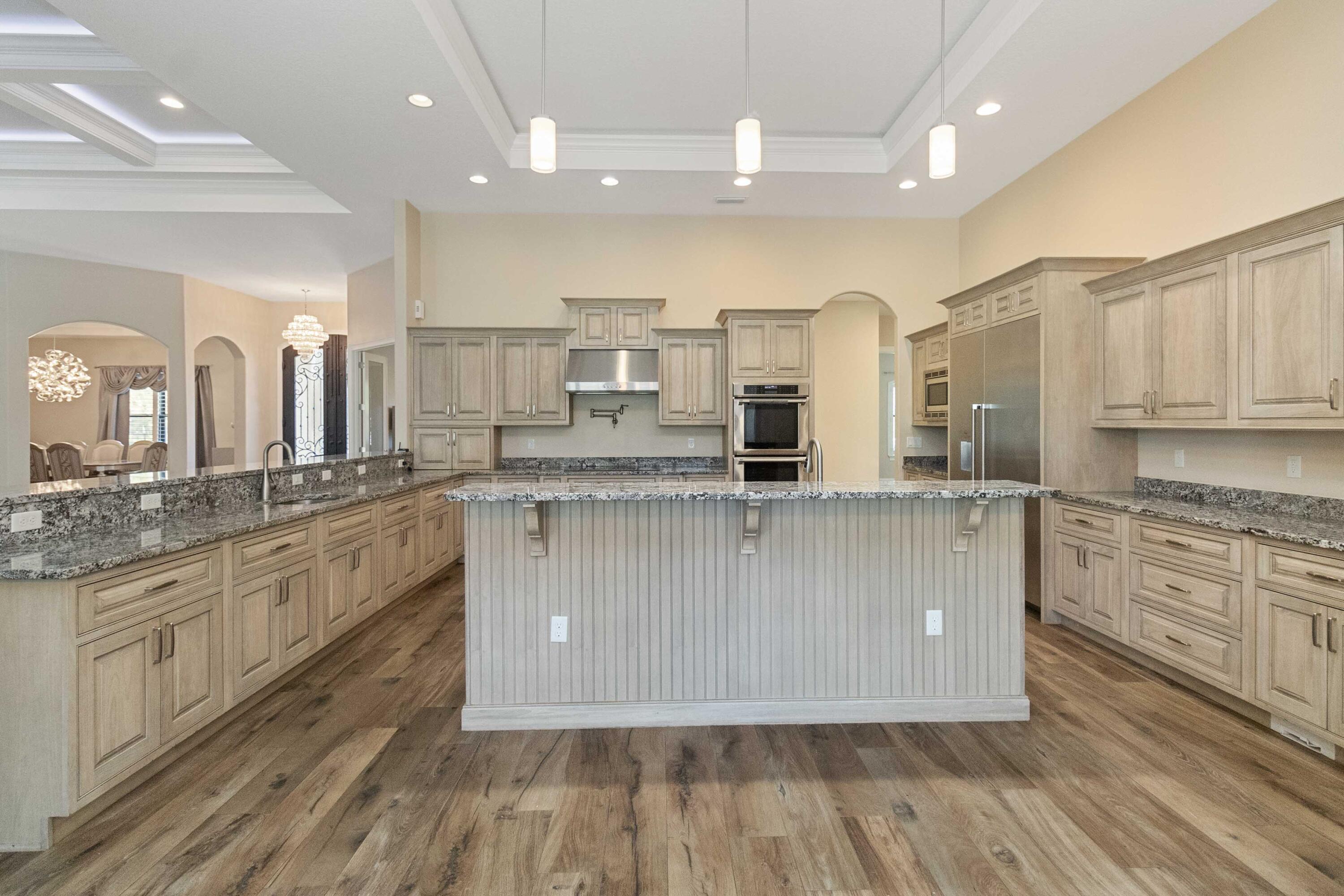 3640 Corey Road Grant Valkaria, FL 32950 - Photo 18 of 77 a large kitchen with stainless steel appliances granite countertop a large stove a sink dishwasher and a refrigerator with wooden floor