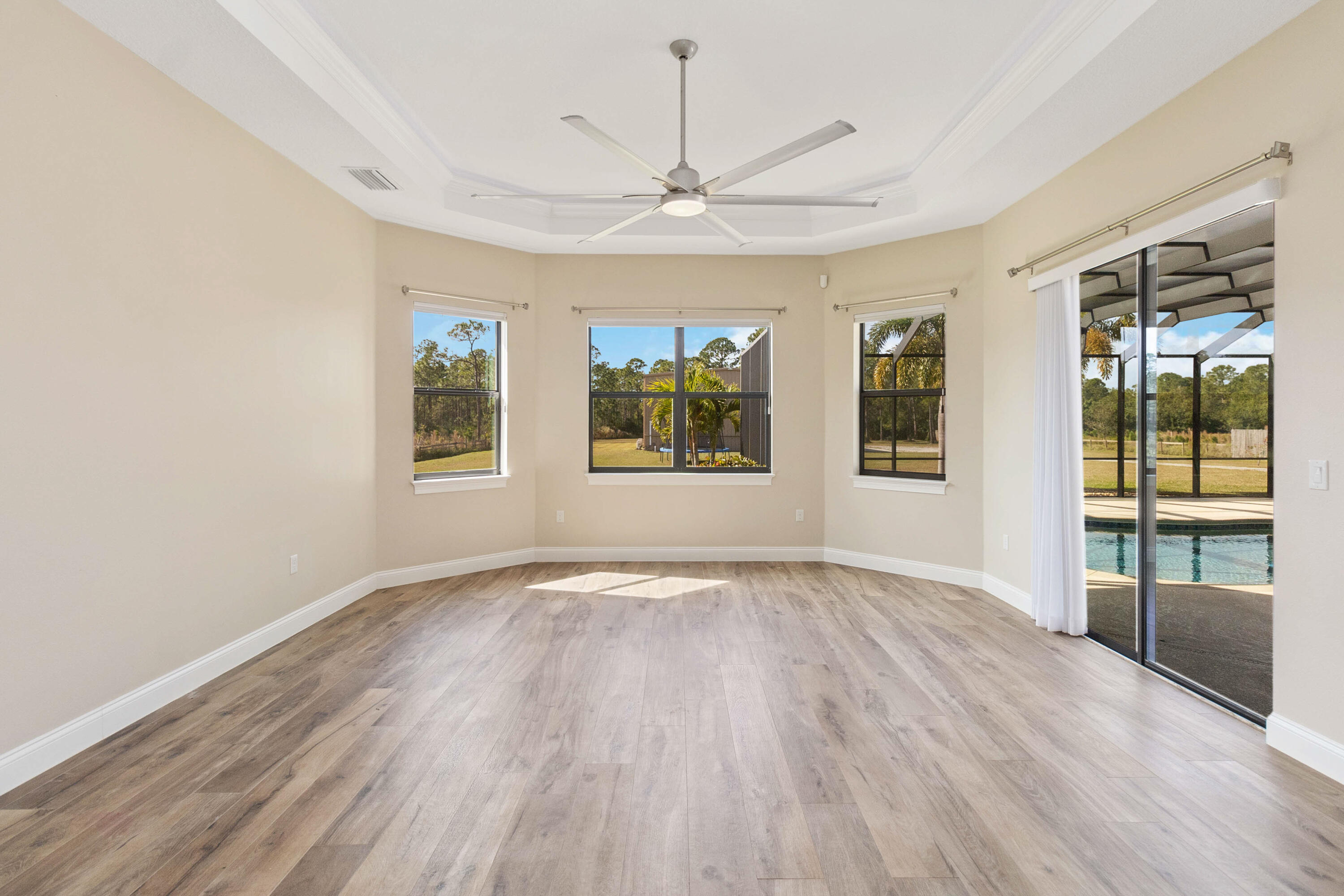 3640 Corey Road Grant Valkaria, FL 32950 - Photo 26 of 77 an empty room with wooden floor chandelier and windows