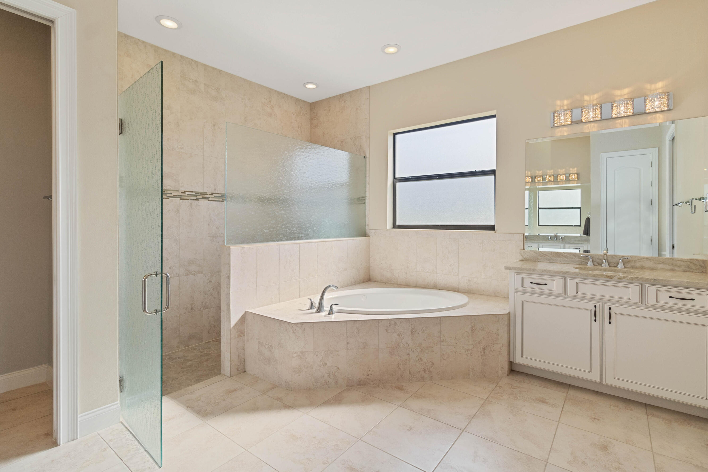 3640 Corey Road Grant Valkaria, FL 32950 - Photo 30 of 77 a spacious bathroom with a bathtub a sink and a mirror