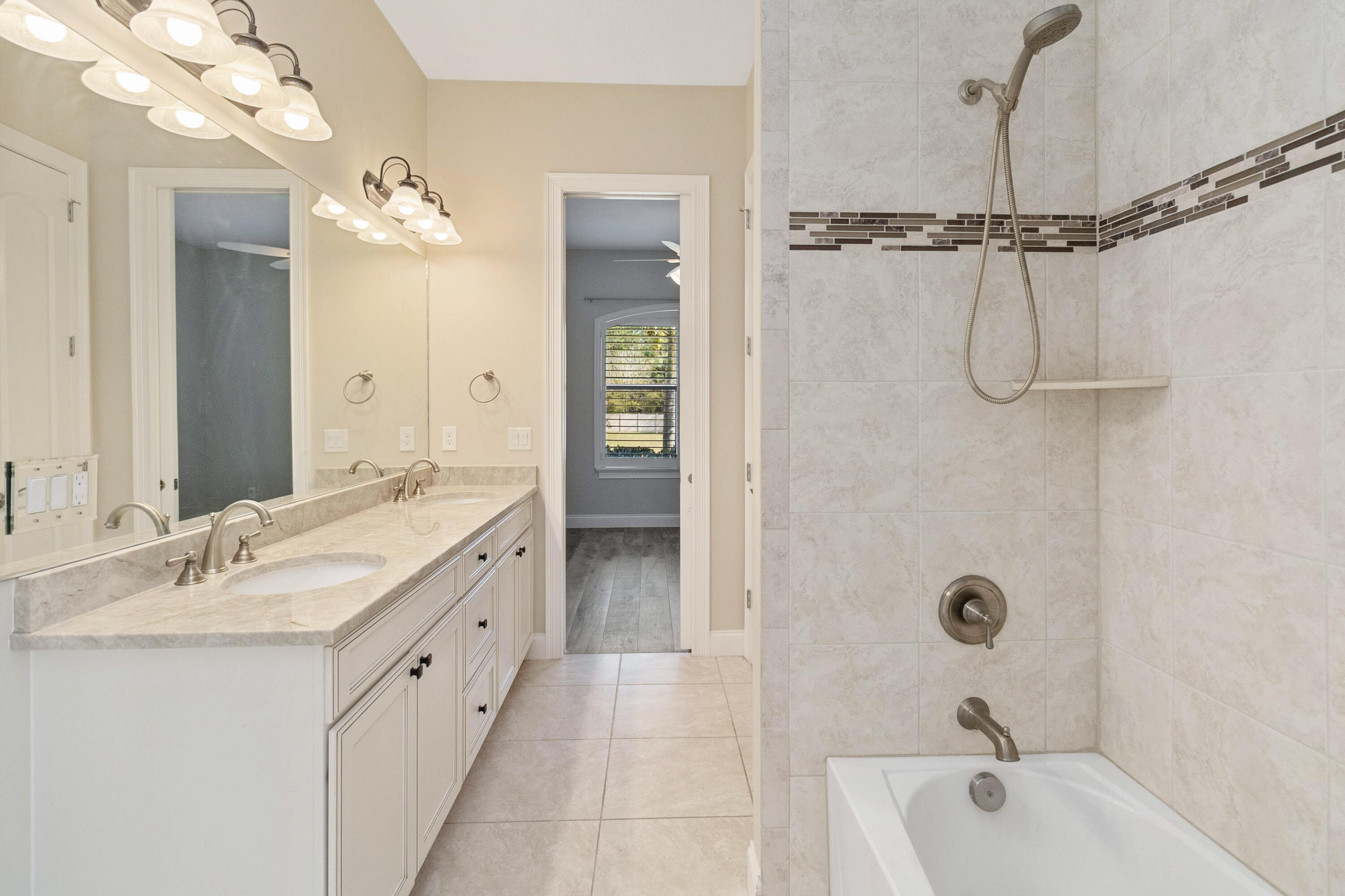 3640 Corey Road Grant Valkaria, FL 32950 - Photo 38 of 77 a bathroom with a granite countertop sink a mirror a bathtub and shower