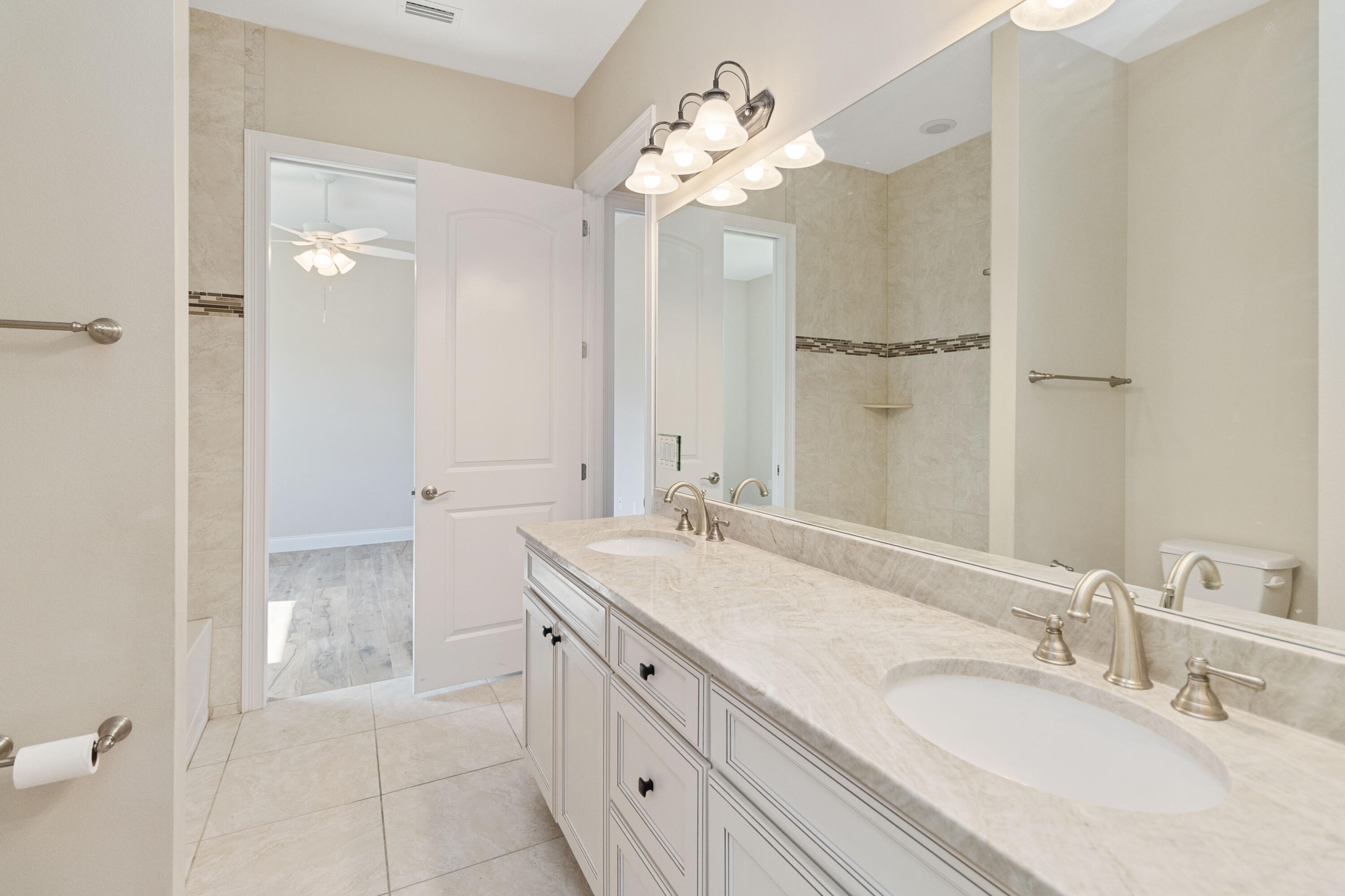 3640 Corey Road Grant Valkaria, FL 32950 - Photo 39 of 77 a bathroom with a granite countertop sink a mirror and a shower