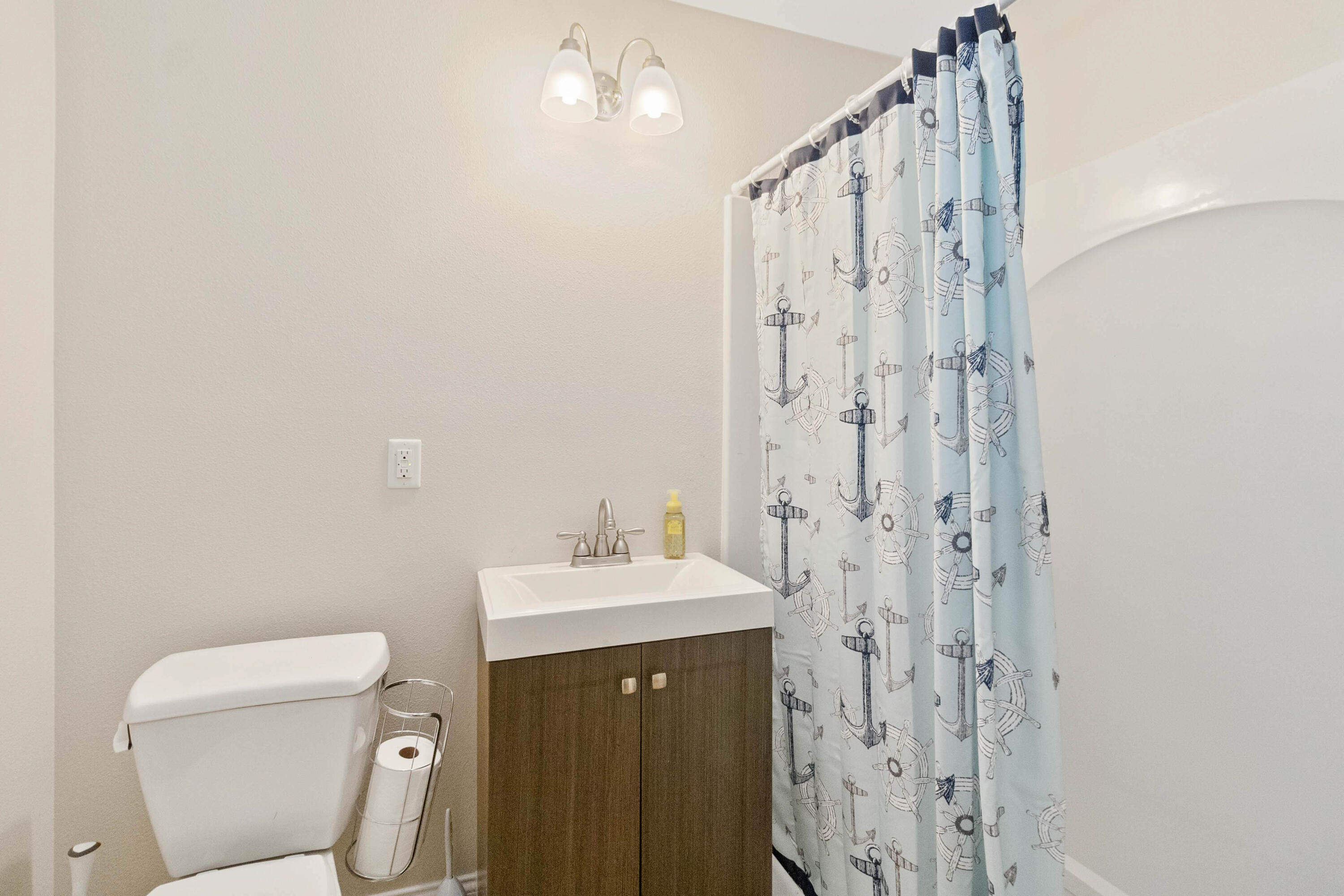 3640 Corey Road Grant Valkaria, FL 32950 - Photo 75 of 77 a bathroom with a sink a toilet and shower curtain