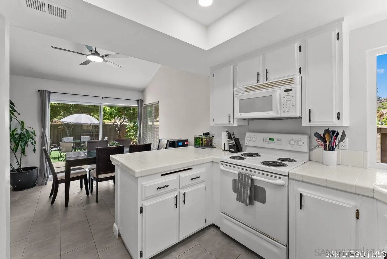 4309 Diegos Court Fallbrook, CA 92028 - Photo 11 of 33 a kitchen with white cabinets and white appliances