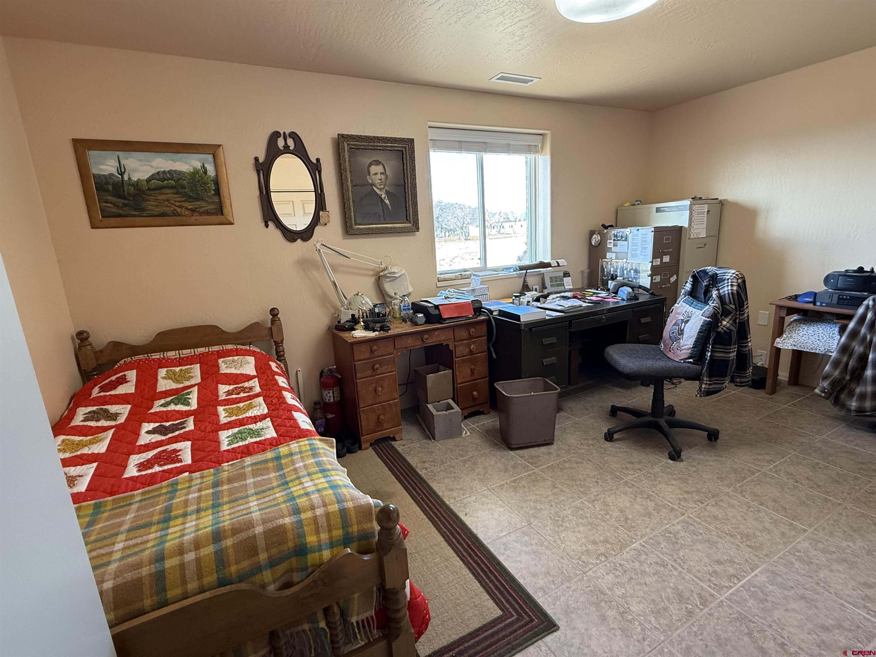 9940 2150th Road Austin, CO 81410 - Photo 9 of 44 a bedroom with a bed a dresser next to a window