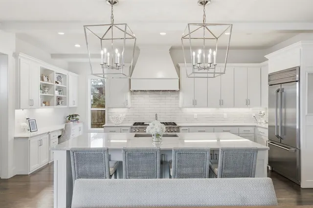 a kitchen with stainless steel appliances granite countertop a sink refrigerator and cabinets