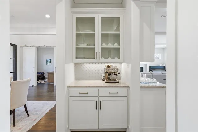 a kitchen with white cabinets and window