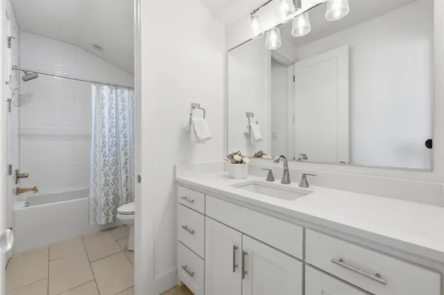 a bathroom with a double vanity sink a mirror and a bathtub