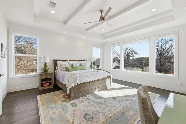 a bed sitting in a spacious bedroom next to a window