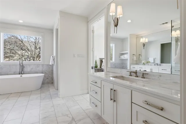 a spacious bathroom with a bathtub sink and mirror