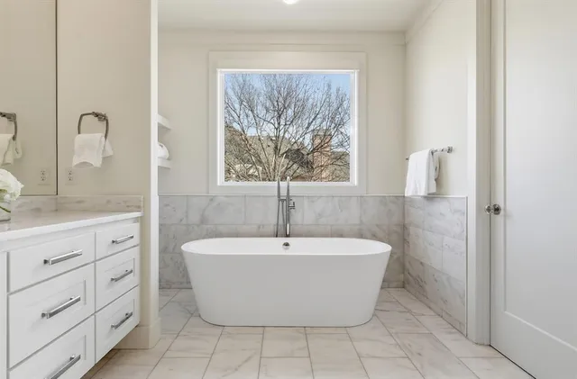 a white bath tub sitting in a bathroom next to a sink