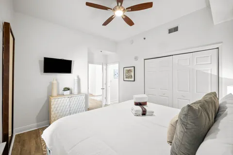 a bedroom with a bed and a flat tv screen on dresser