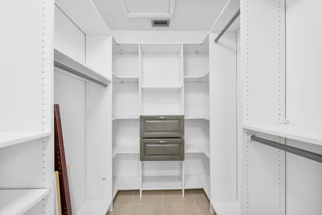 a view of walk in closet with empty racks