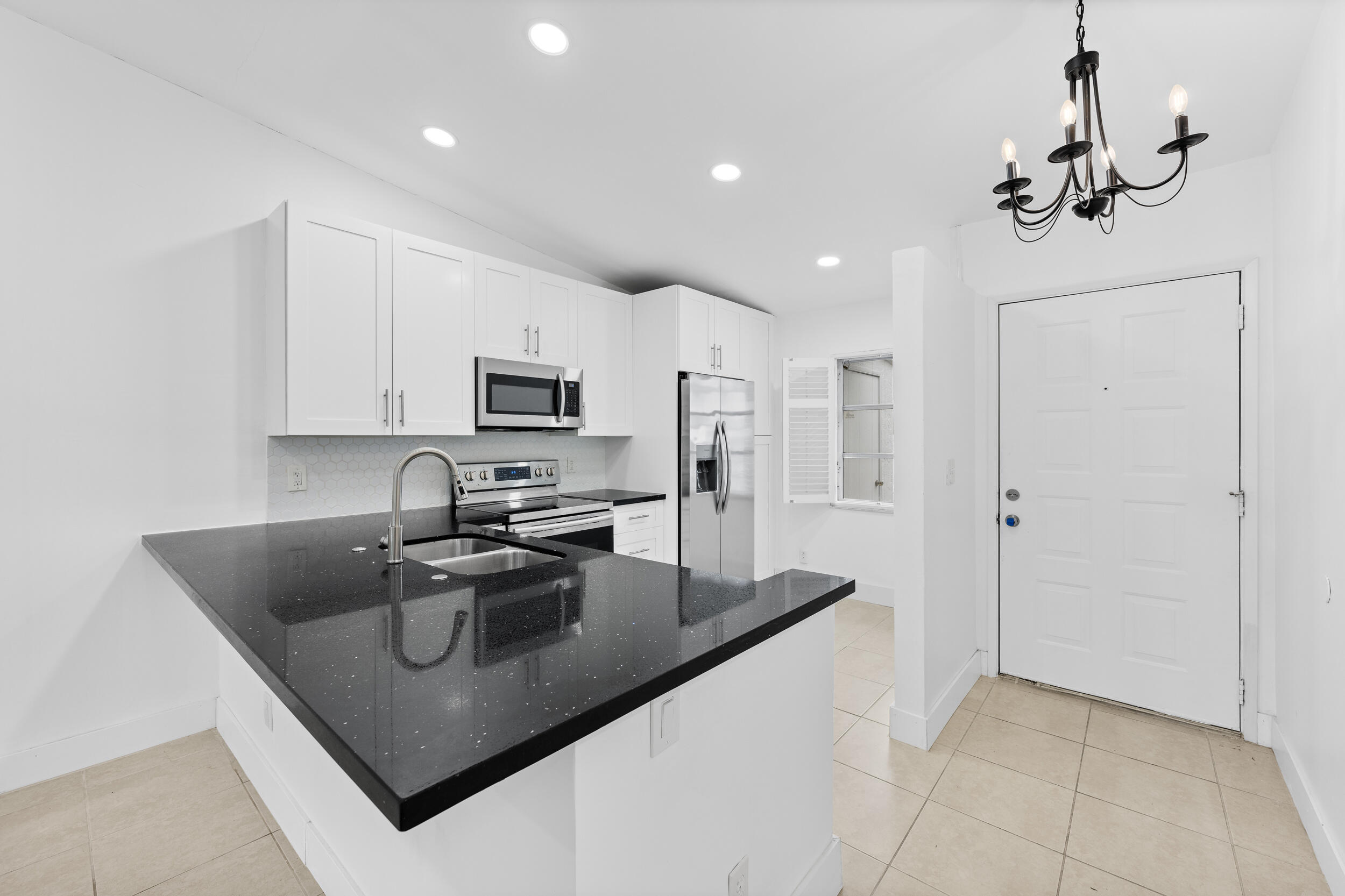 8888 Sunscape Lane Boca Raton, FL 33496 - Photo 4 of 35 a kitchen with stainless steel appliances granite countertop a sink a refrigerator and a granite counter tops