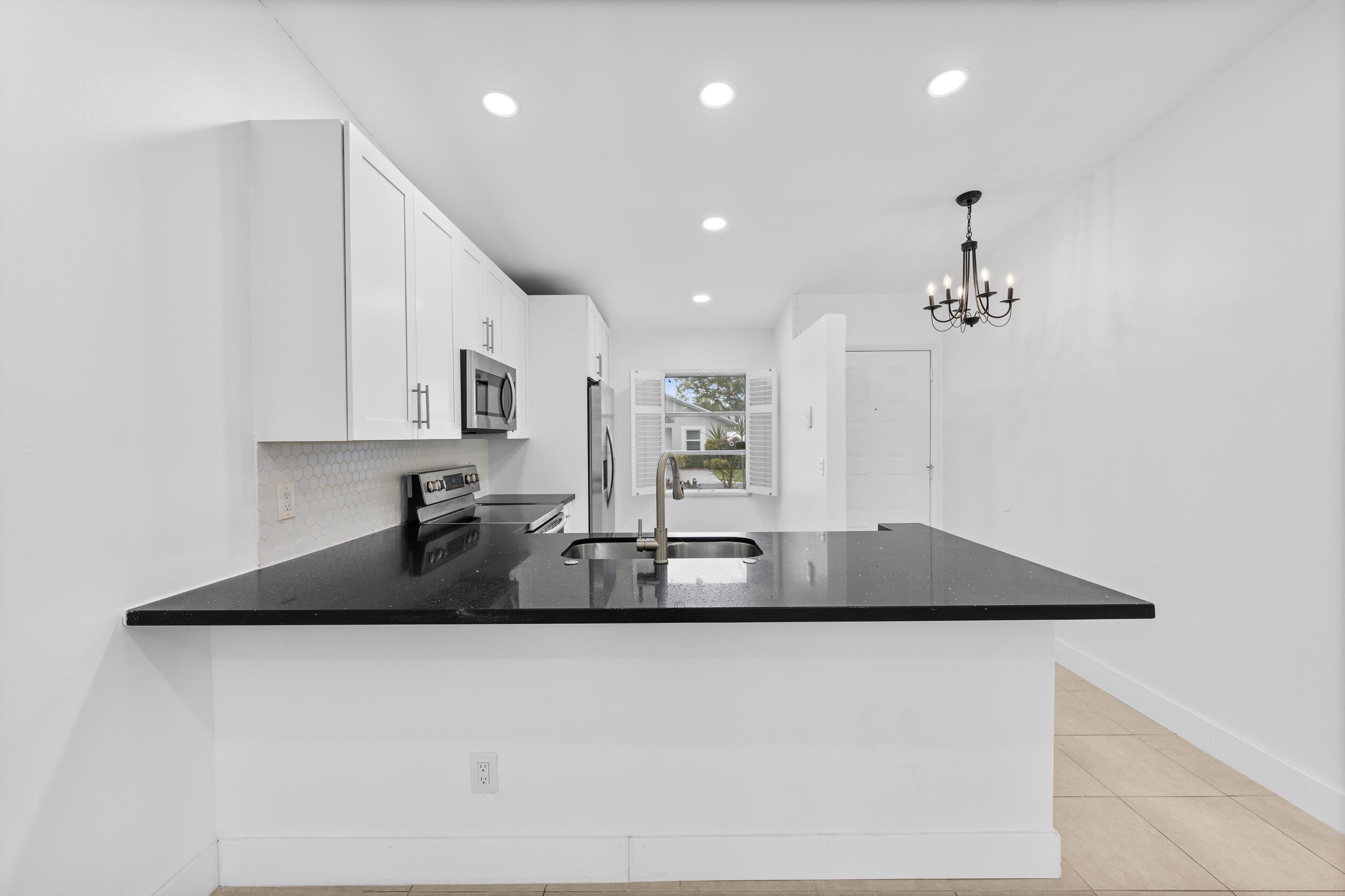 8888 Sunscape Lane Boca Raton, FL 33496 - Photo 5 of 35 a kitchen with kitchen island granite countertop a sink a stove a refrigerator and a cabinets