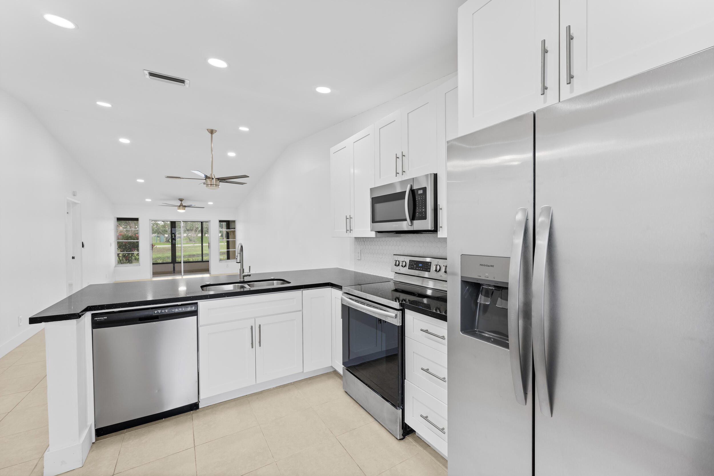 8888 Sunscape Lane Boca Raton, FL 33496 - Photo 6 of 35 a kitchen with white cabinets and appliances