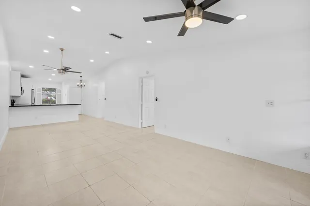 an empty room with a ceiling fan and a window