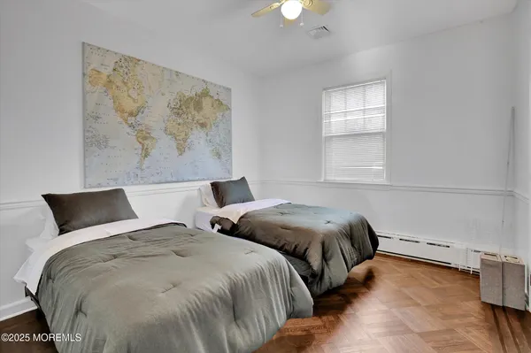 a bedroom with two beds and a painting on the wall