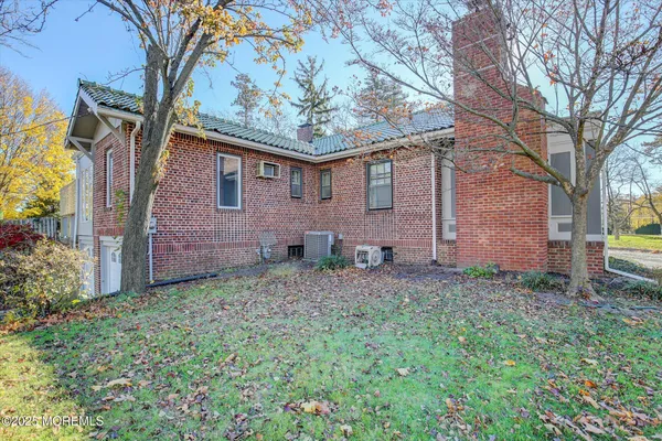 a backyard of a house with plants and large tree