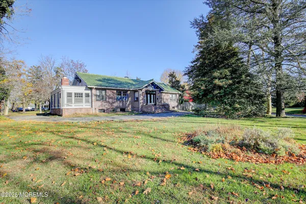 a view of a house with a big yard with large trees