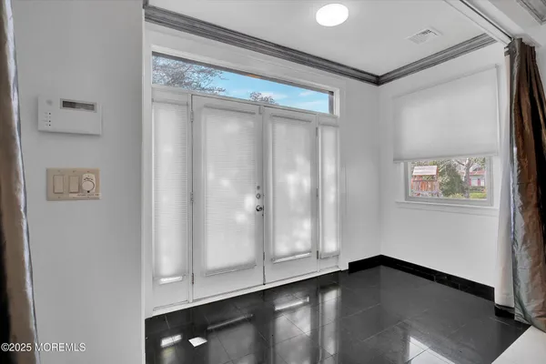 a view of an empty room with wooden floor and closet