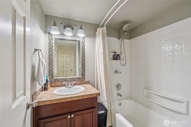 a bathroom with a sink a toilet a mirror and shower