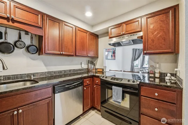 a kitchen with granite countertop a stove and a sink