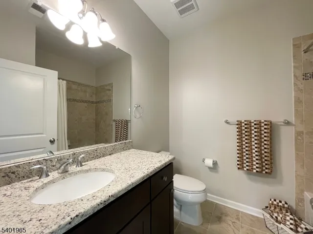 a bathroom with a granite countertop sink toilet and a mirror