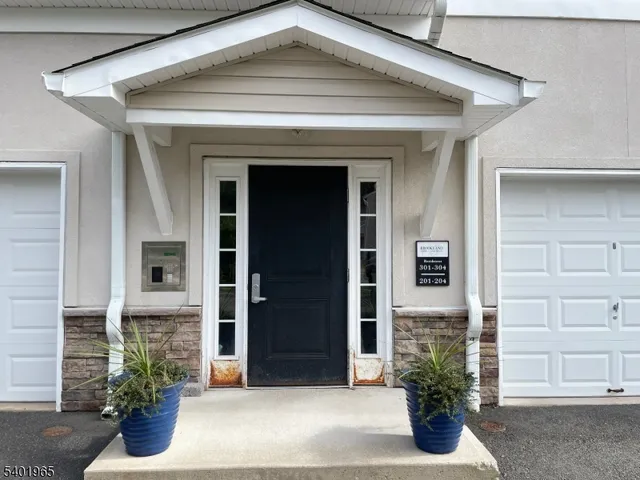 a front view of a house with potted plants