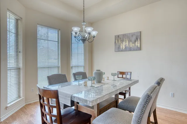 a dining room with furniture a chandelier and wooden floor