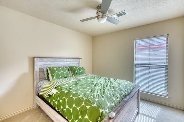a bed sitting in a bedroom next to a window