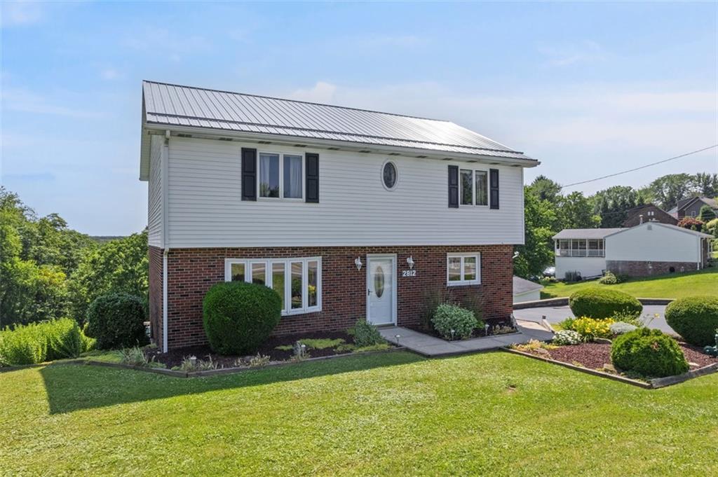 2812 Ridge Rd Extension Baden, PA 15005 - Photo 1 of 44 a front view of a house with garden