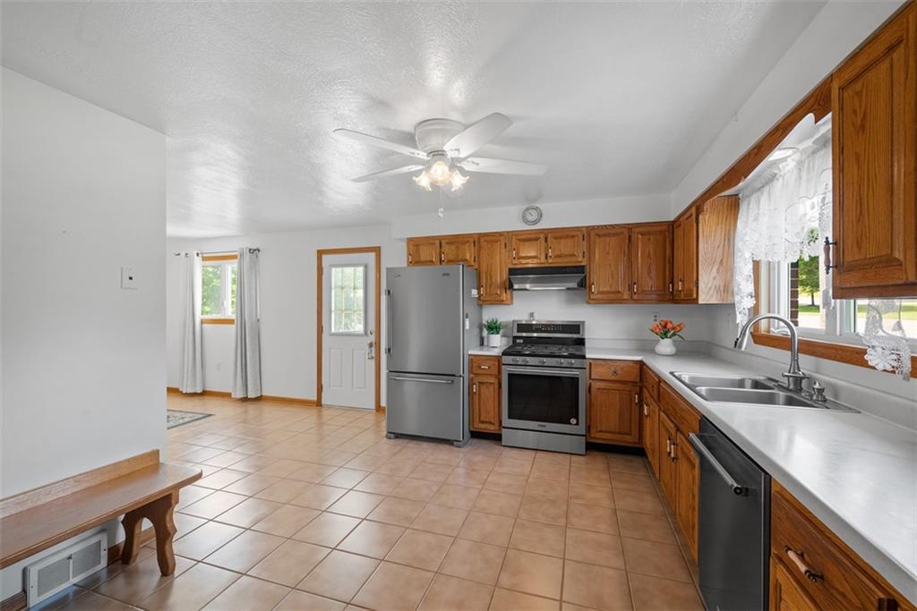 2812 Ridge Rd Extension Baden, PA 15005 - Photo 11 of 44 a kitchen with stainless steel appliances granite countertop a sink a stove a refrigerator cabinets and a window