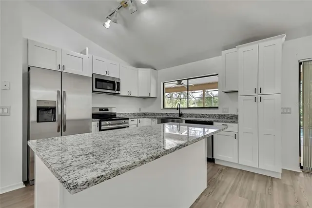 a kitchen with granite countertop white cabinets and a stove