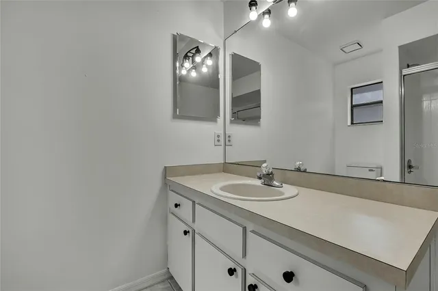 a bathroom with a toilet sink vanity and shower