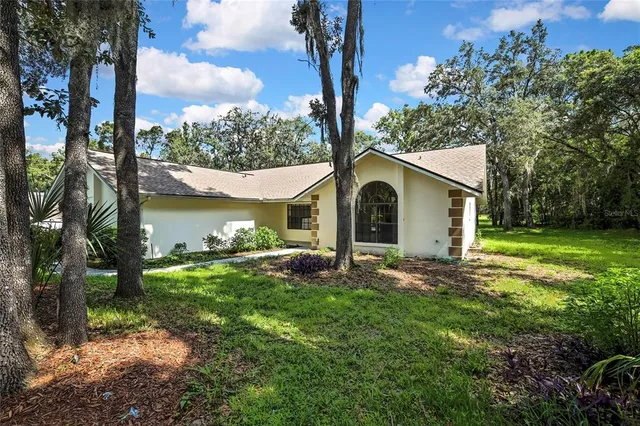an aerial view of residential houses with outdoor space and trees all around