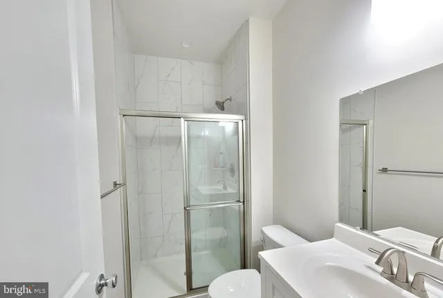 a very nice looking kitchen with stainless steel appliances granite countertop a refrigerator a sink a stove and white cabinets with wooden floor