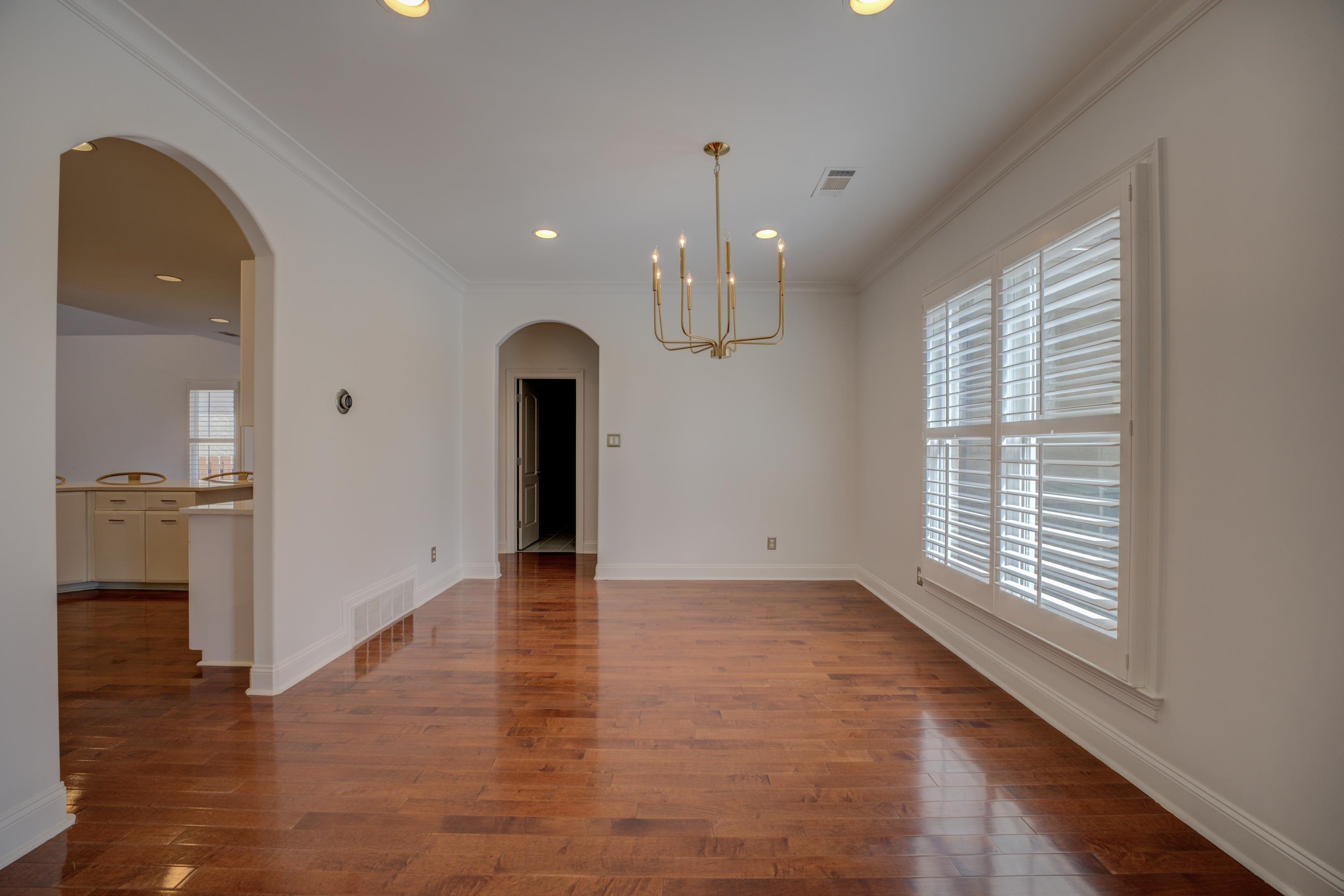1844 Penshurst Drive Collierville, TN 38017 - Photo 7 of 40 Unfurnished dining area featuring visible vents, a notable chandelier, and wood finished floors
