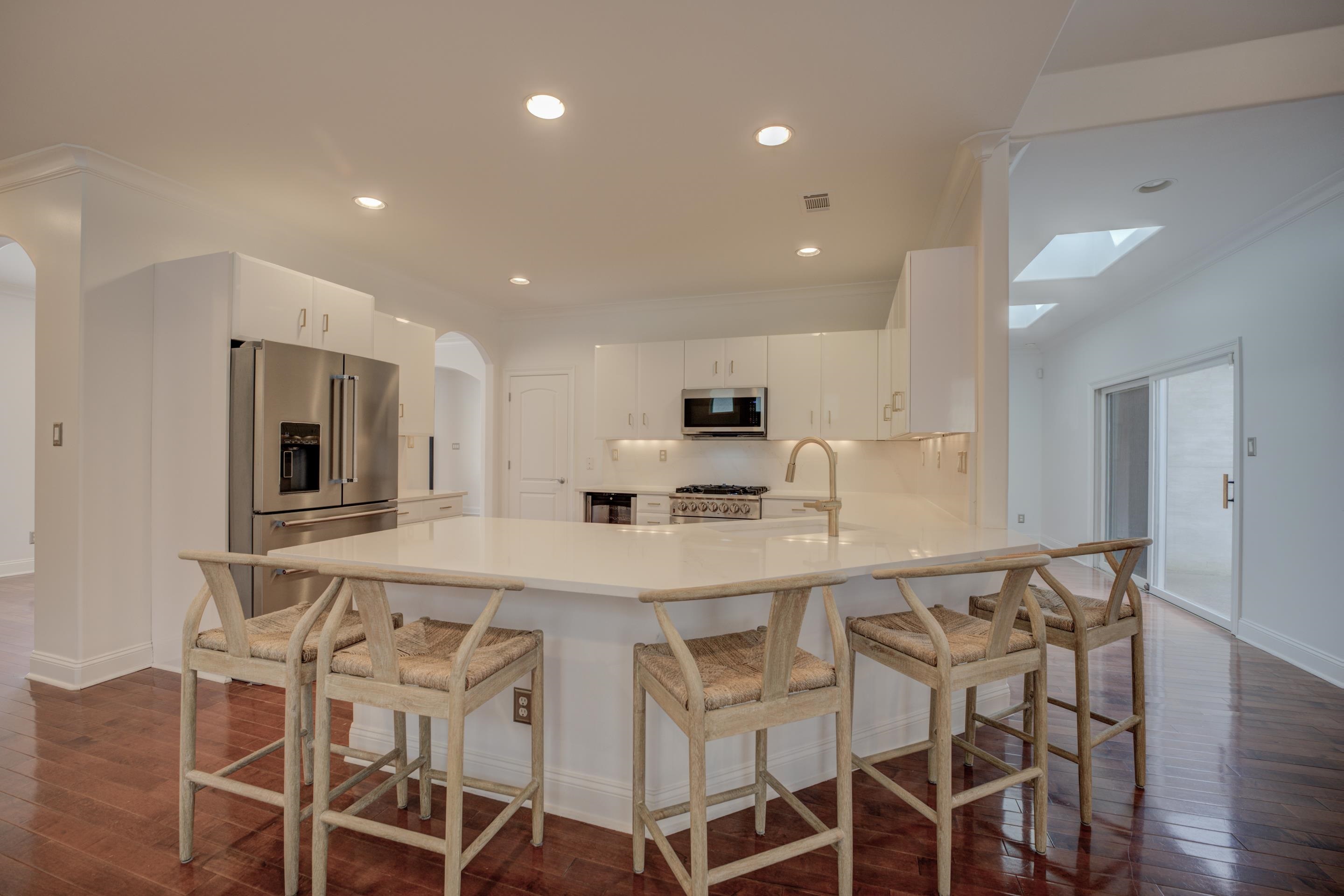1844 Penshurst Drive Collierville, TN 38017 - Photo 8 of 40 Kitchen featuring a peninsula, arched walkways, dark wood-style flooring, a sink, and stainless steel appliances
