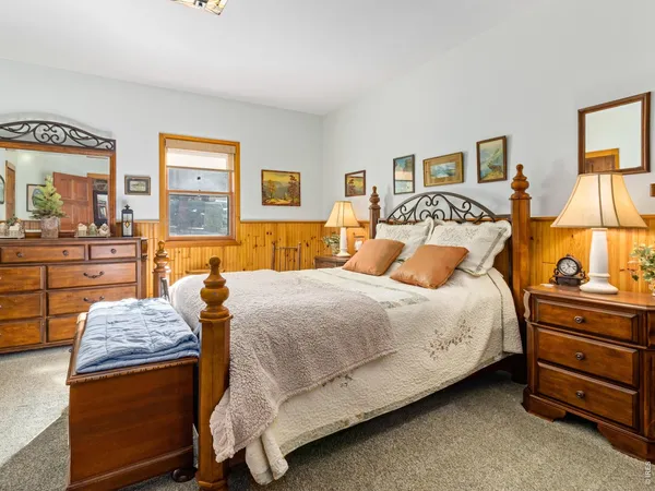 a bedroom with a bed and painting on the wall