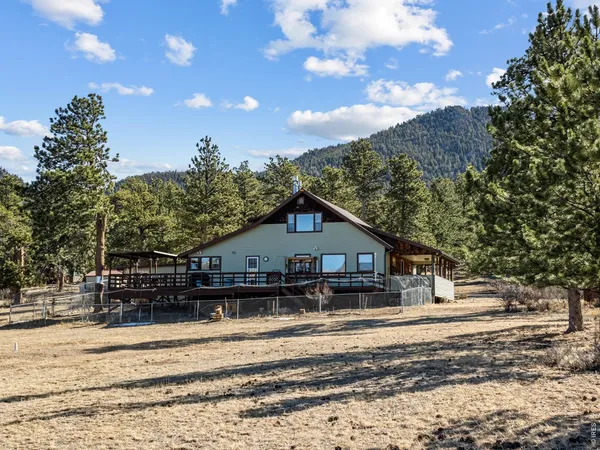 a view of a house next to a road with large trees