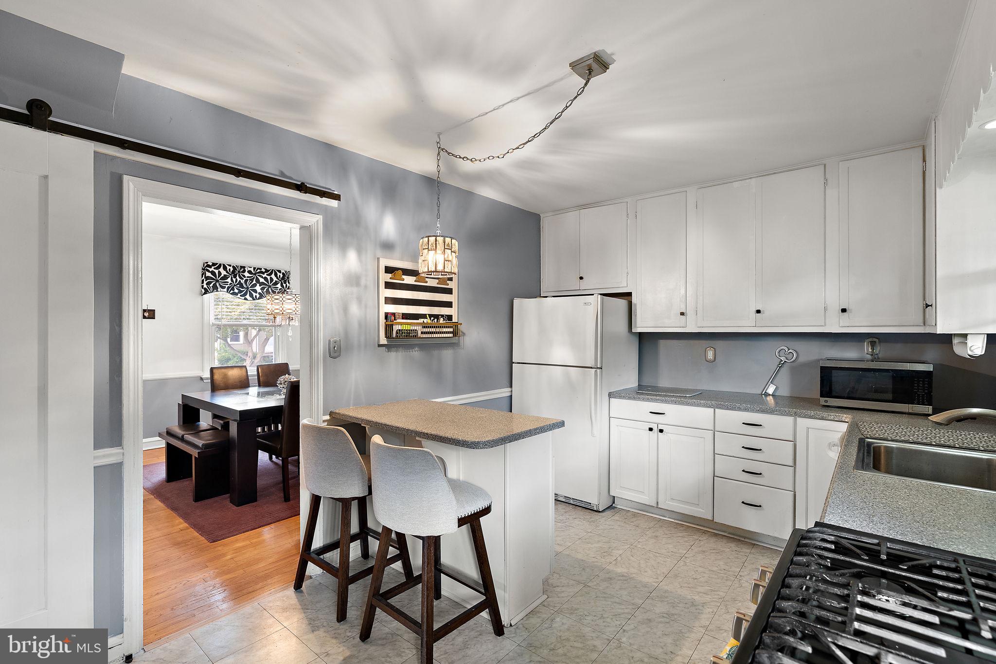 305 Troy Avenue Wilmington, DE 19804 - Photo 10 of 26 a kitchen with a stove a refrigerator and a dining table