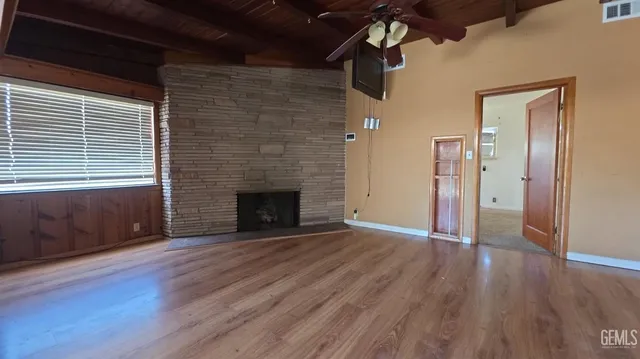 a view of a livingroom with wooden floor and a fireplace