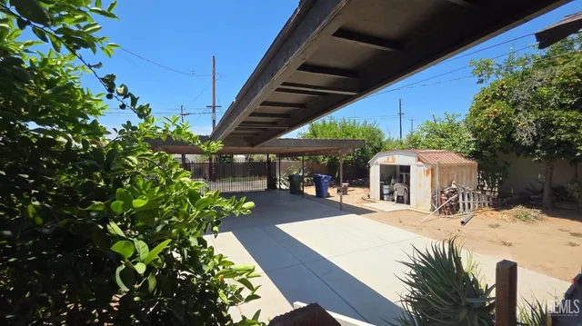 a view of a patio with table and chairs potted plants and large tree